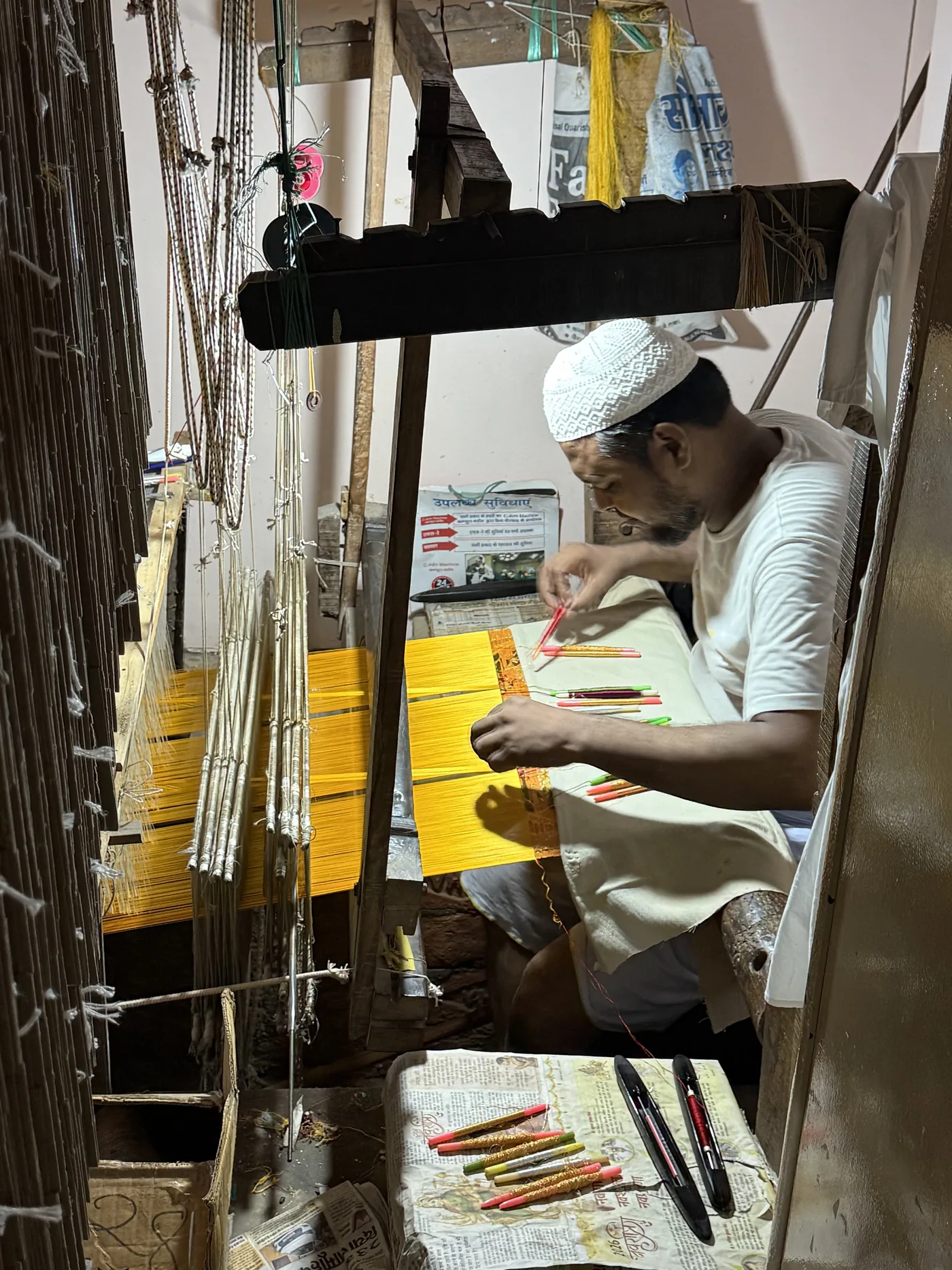 KashiFab Banarasi silk hand loom artisan with coloured bobbins weaving in Varanasi