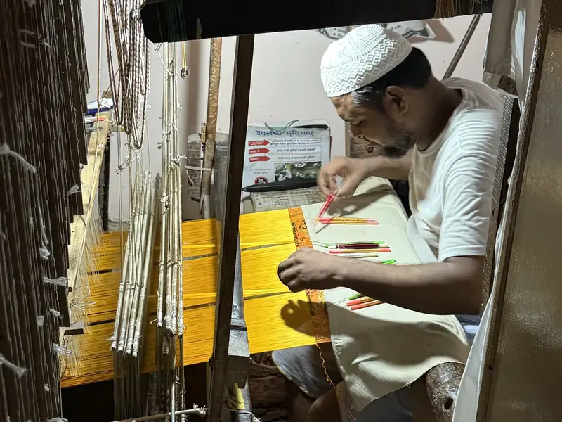 KashiFab Banarasi silk hand loom artisan with coloured bobbins weaving in Varanasi